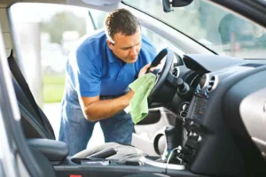 homme entrain de laver l'interrieur de la voiture avec un chifon