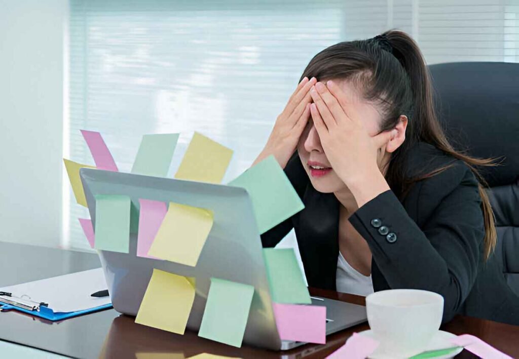 Femme fatiguée avec un ordinateur portable couvert de notes autocollantes